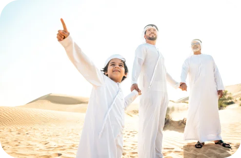 Family wearing traditional clothing in a desert landscape