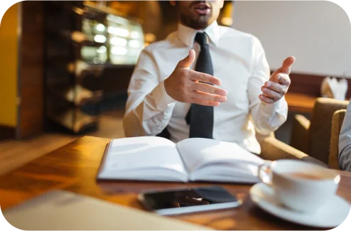 Discussing documents and an open book at a table