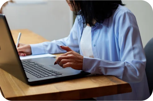 Taking notes while working on a laptop