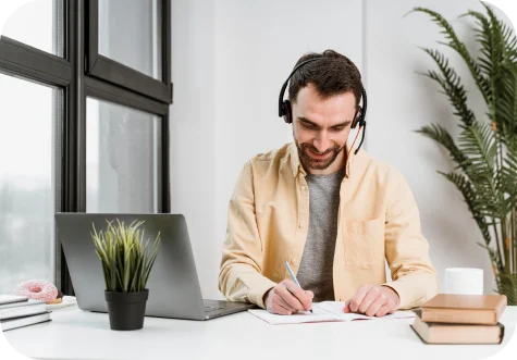 Man wearing a headset while working on a laptop