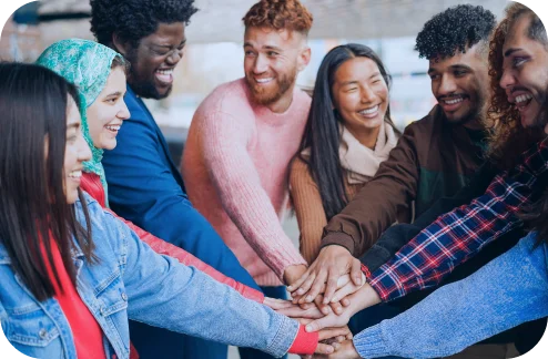 Group of young people stacking their hands together
